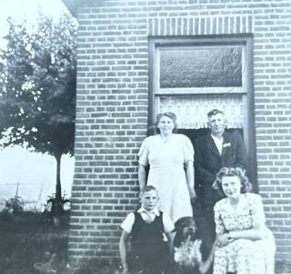 Wolter en Hiltje Schaap-Ruiter met hun kinderen Klaas en Martha voor hun huis in Langelille-Munnekeburen. De foto is genomen rond 1949.